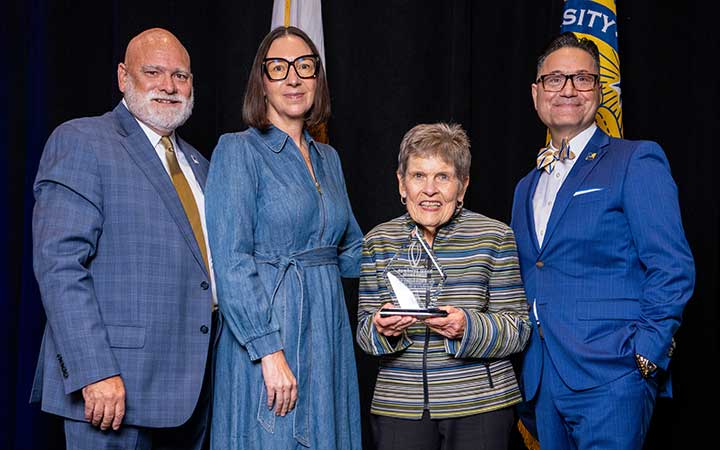 Four people pose for picture, including UC Merced Trustee Emeritus Kenni Friedman.